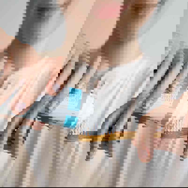 Person applying toothpaste to a toothbrush