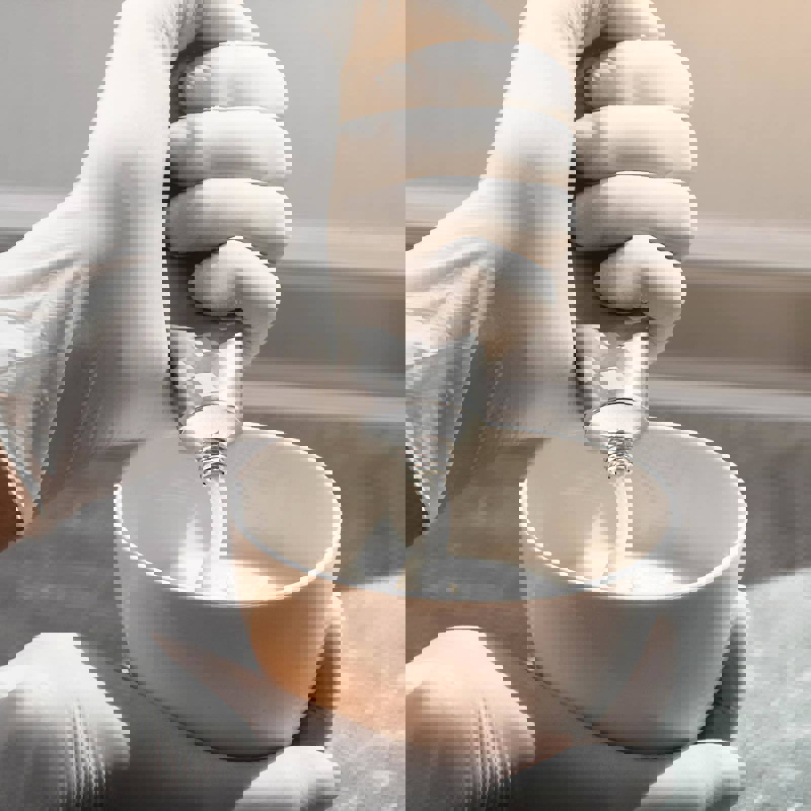 Hairdresser squeezing tube of colour into a bowl