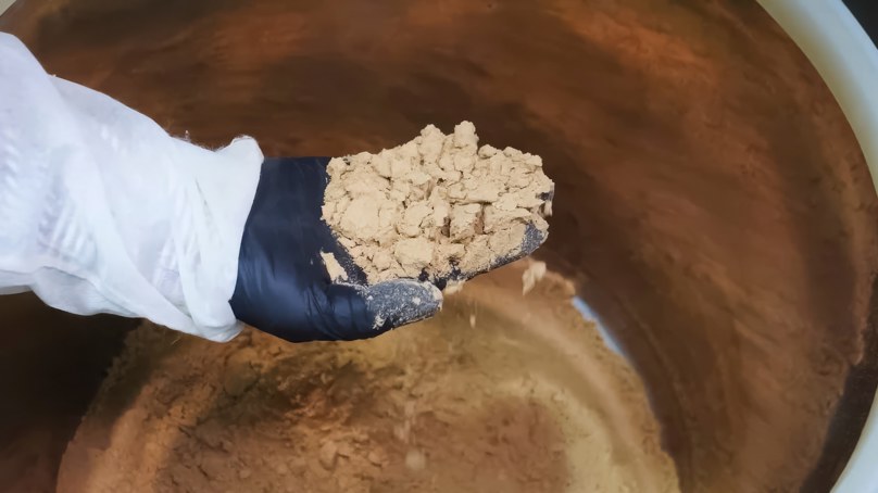 Person Holding Caked Powder In Factory