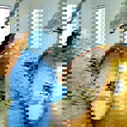 Worker scooping granules in a factory