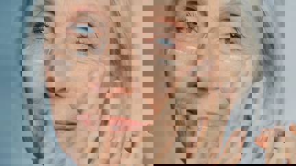 Senior Woman Applying Cream To Face