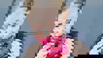 Girl Biting Into Doughnut