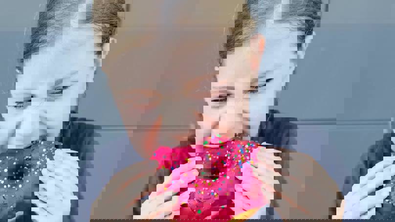 Girl Biting Into Doughnut