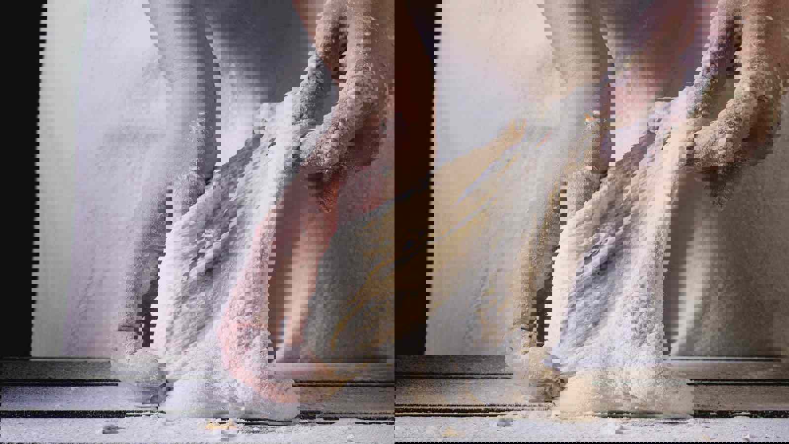 Baker stretching dough in hands