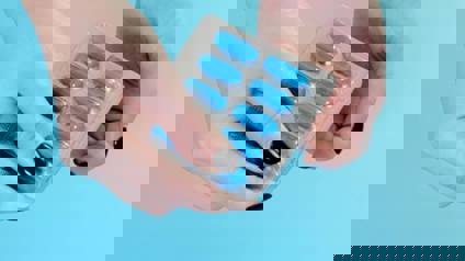 Hands Pushing Out Capsule From Blister Pack