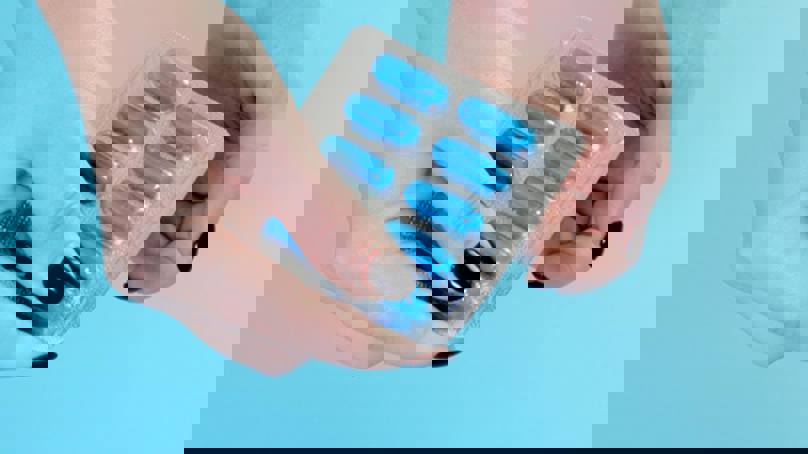 Hands Pushing Out Capsule From Blister Pack