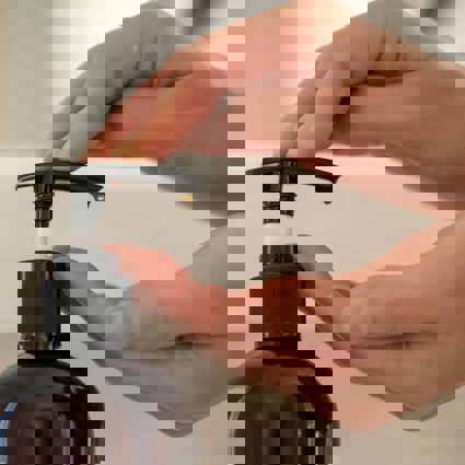 Person pumping handwash from a bottle