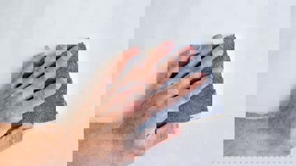 Person Sanding A Wall