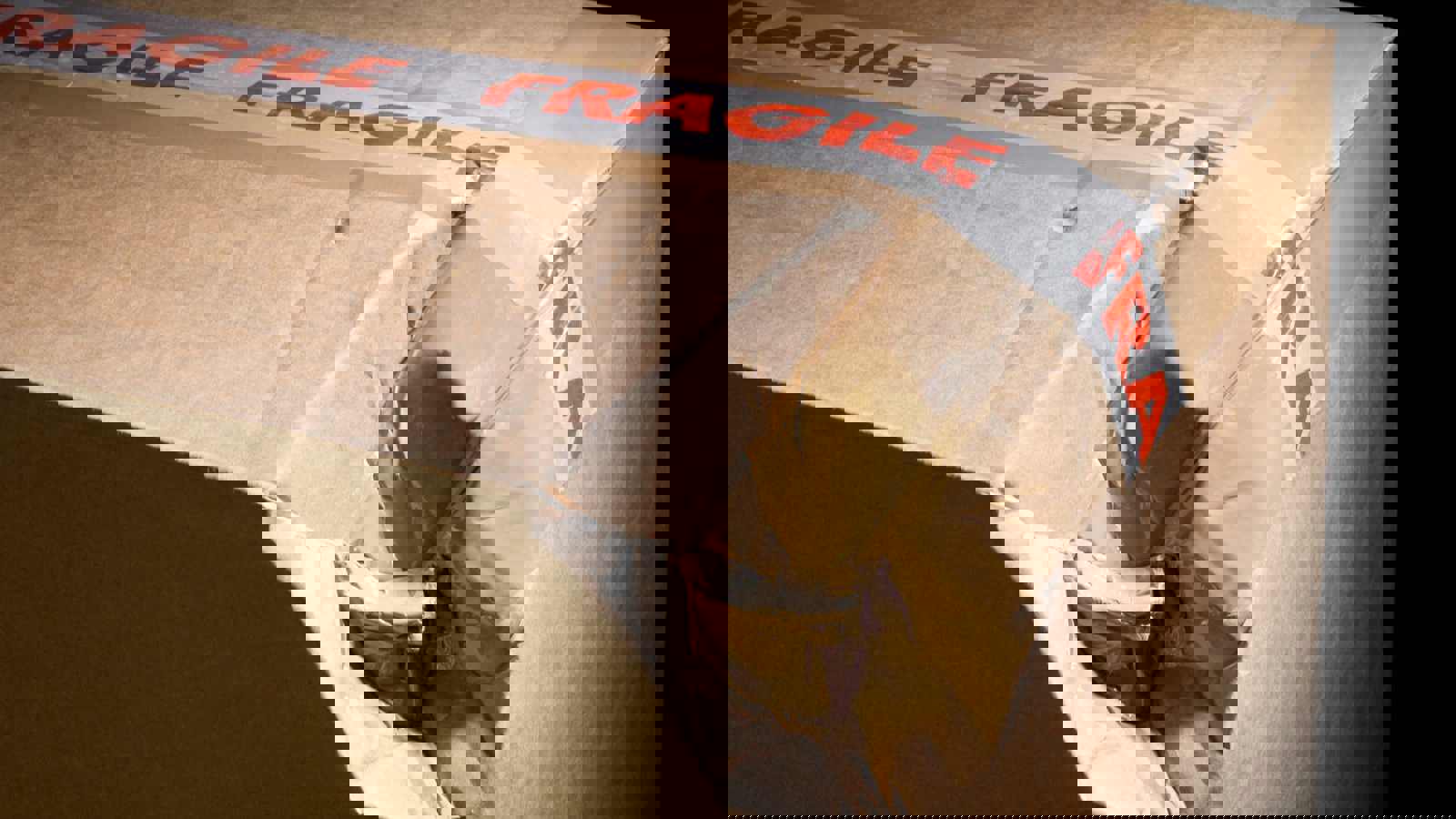 Cardboard box with fragile sticker crushed in corner