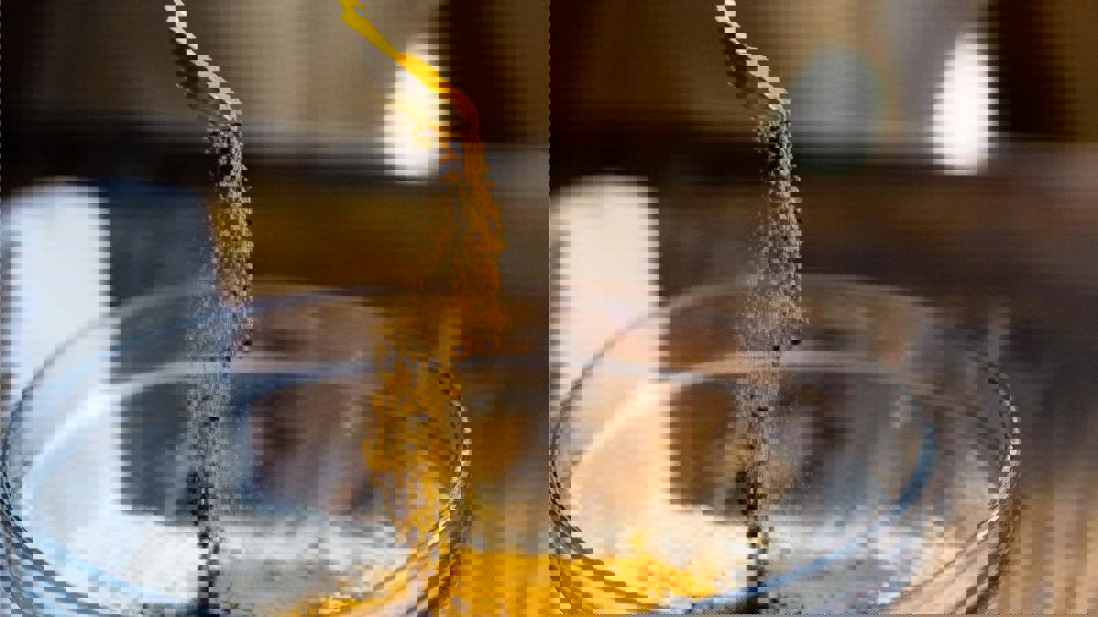 Person scooping powdered ingredients into a bowl