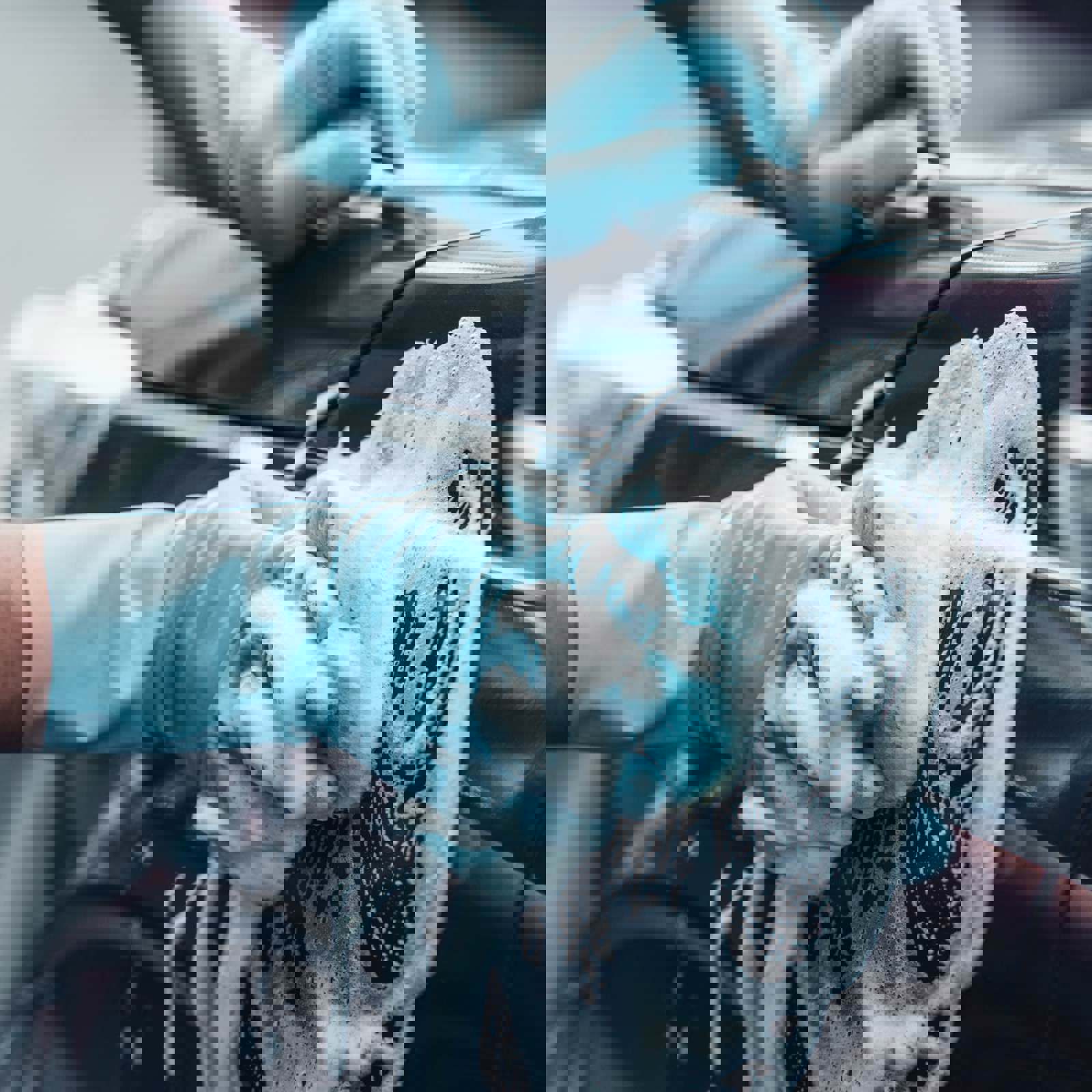 Person washing car with sponge