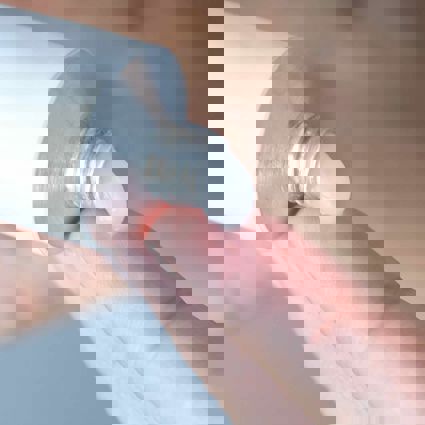 Person squeezing ointment from tube onto finger