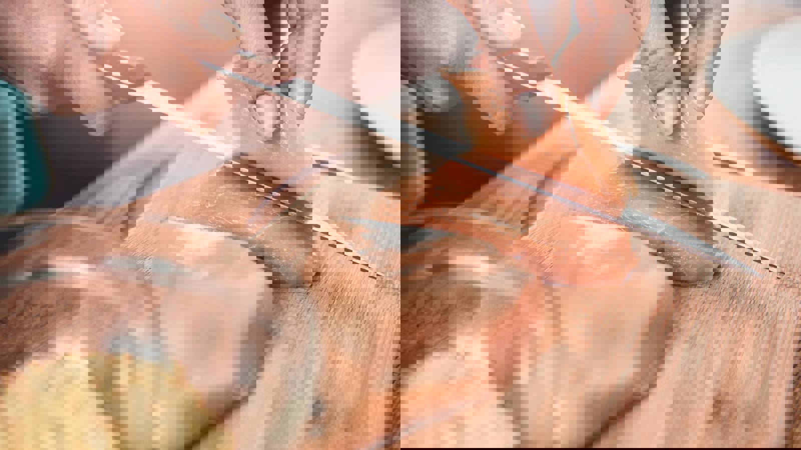 Person slicing raw chicken breast