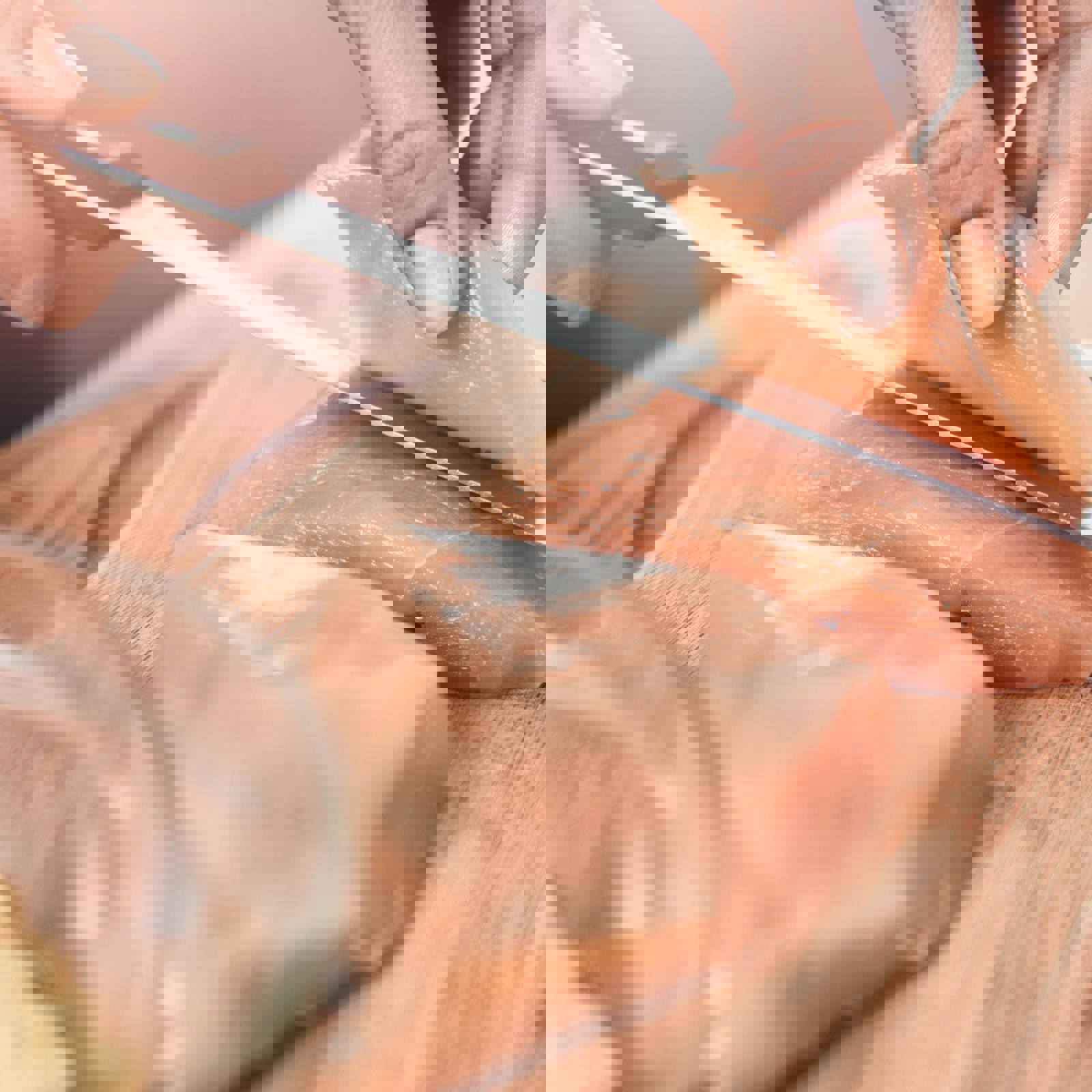 Person slicing raw chicken breast