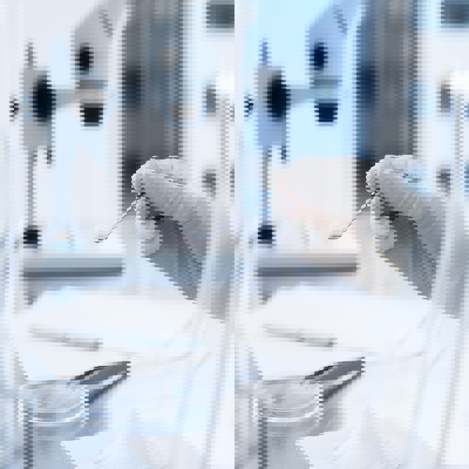 Technician scooping white powder in a laboratory