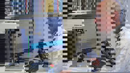 Man In White Coat Sitting At Pc Using. Texture Analyser