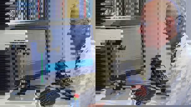 Man In White Coat Sitting At Pc Using. Texture Analyser