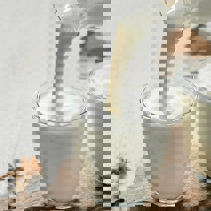 Pouring kefir from a bottle into drinking glasses