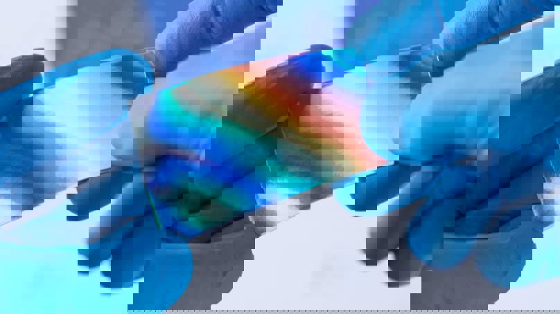 Hands Wearing Blue Gloves Holding Reflective Material