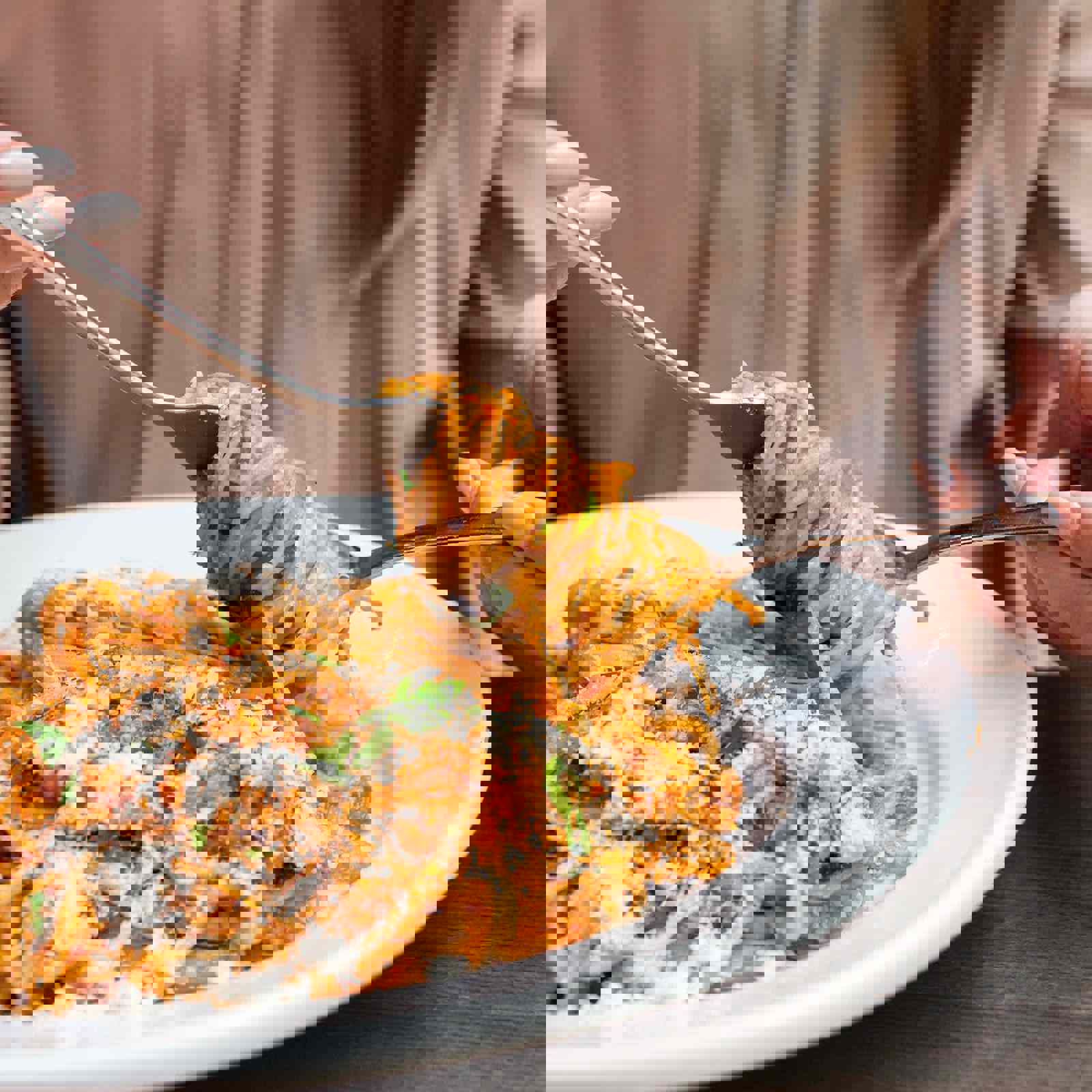 Person winding spaghetti around a fork