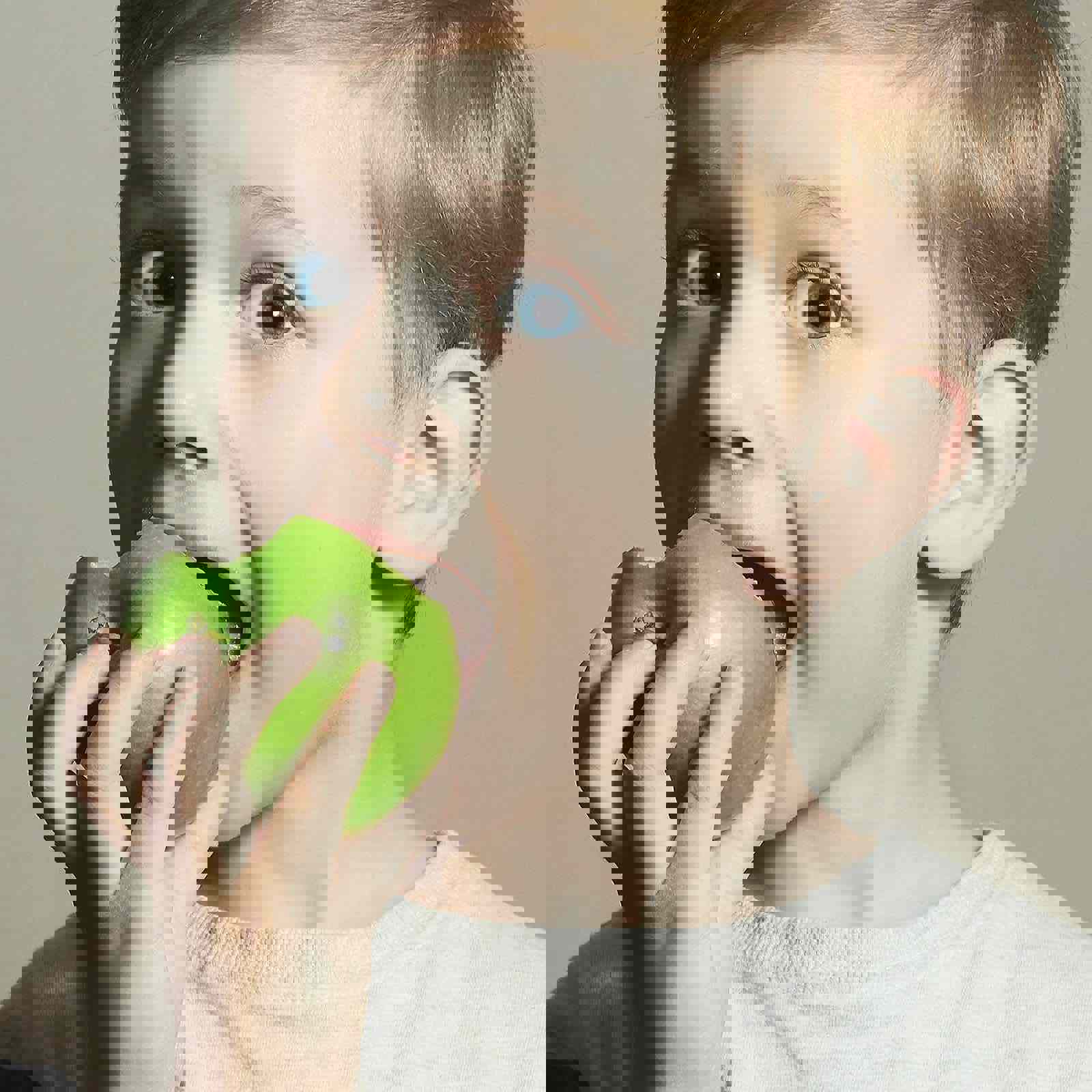 Child biting into an apple