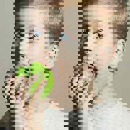 Child biting into a crunchy green apple