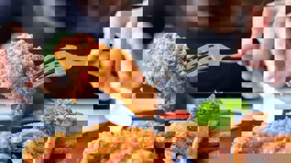 Person Picking Up Fried Chicken With A Fork