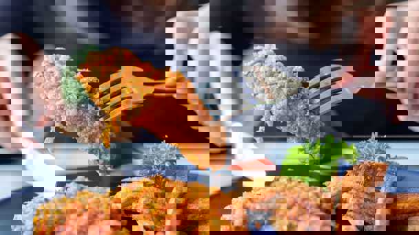 Person Picking Up Fried Chicken With A Fork