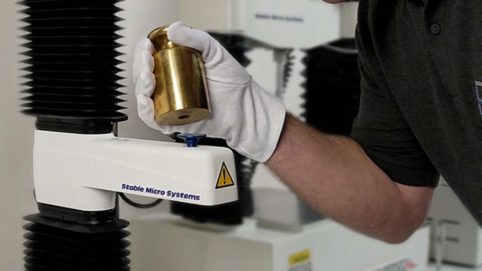 A technician calibrating a Texture Analyser using a calibration weight