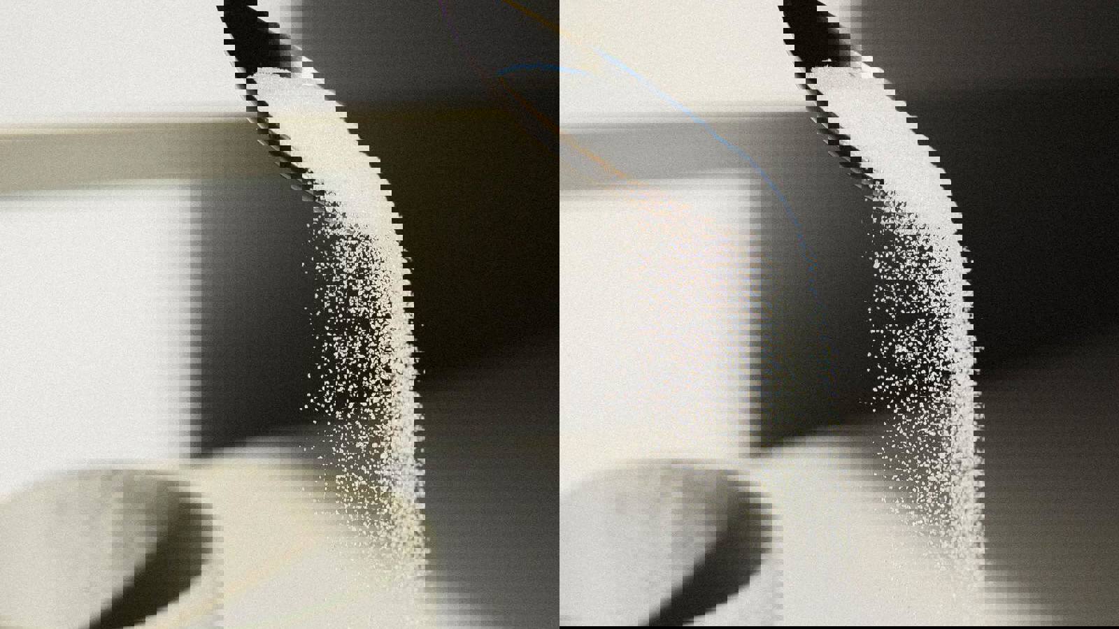 Grains of sugar flowing off a spoon