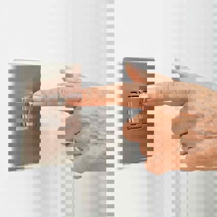 Person switching on a wall mounted switch