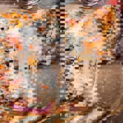 Slice of cheesy pizza being separated 