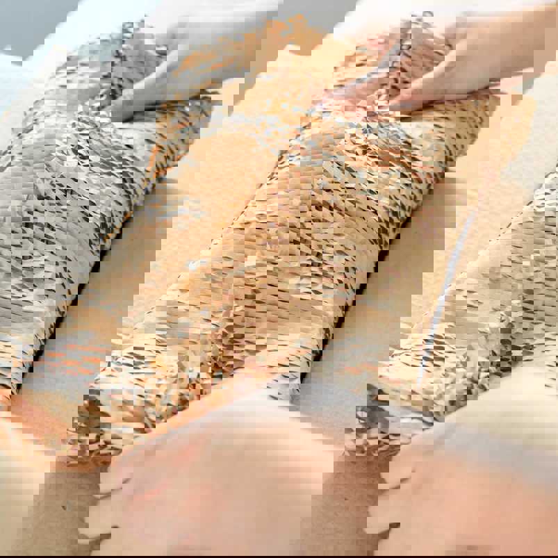 Person handling a package wrapped in eco friendly honeycomb paper
