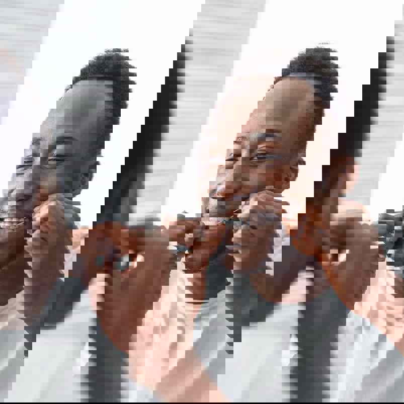 Person flossing teeth in mirror