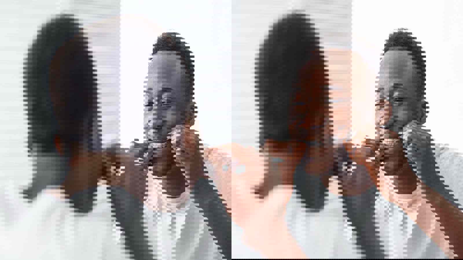 Person flossing teeth in front of mirror